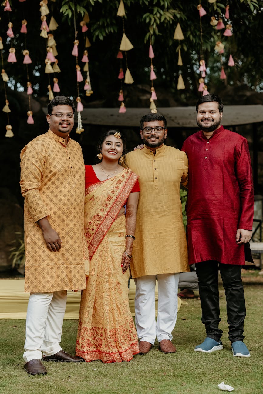 bride and groom in traditional clothing posing with wedding guests