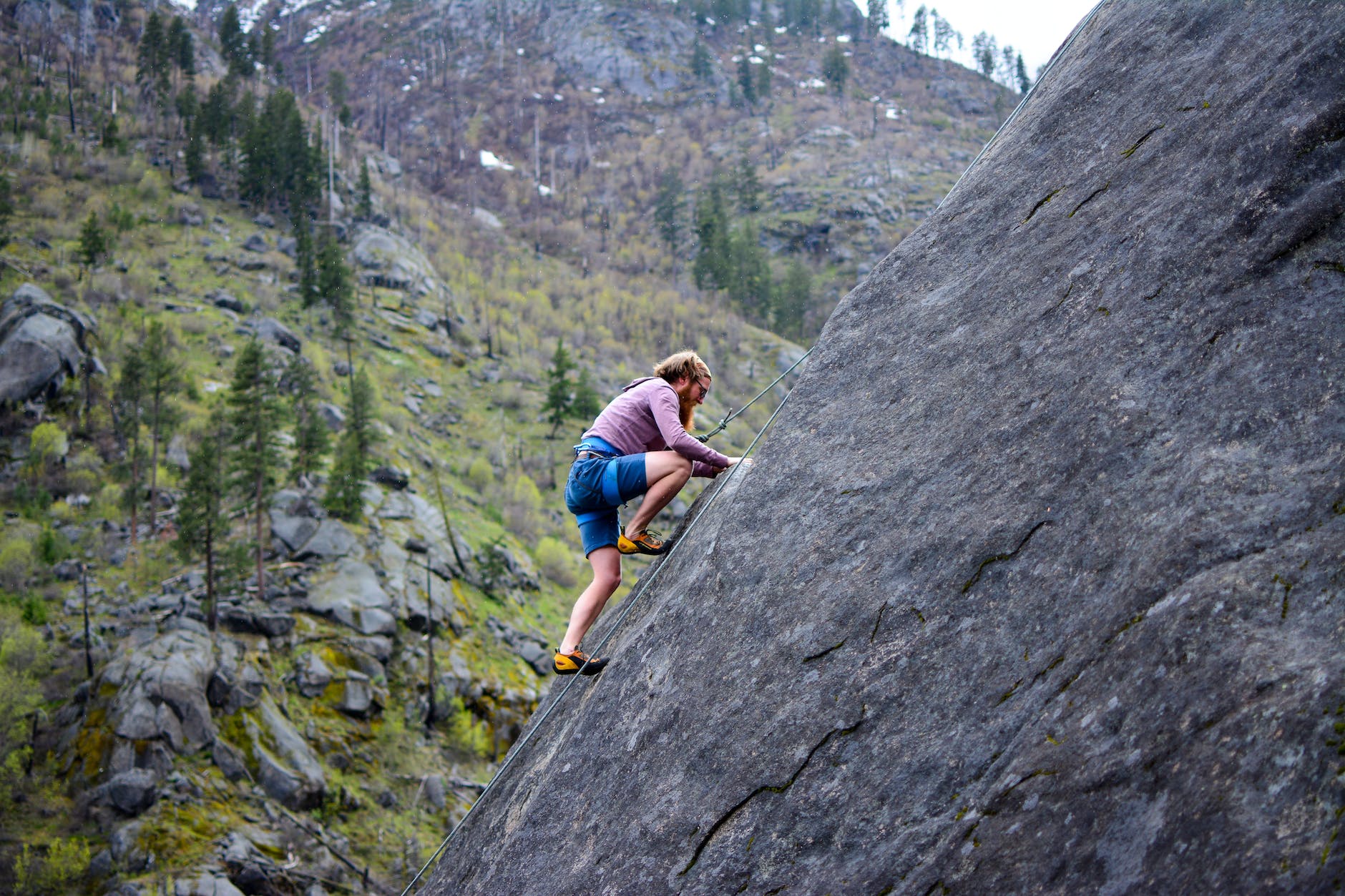 man climbing on rock mountain