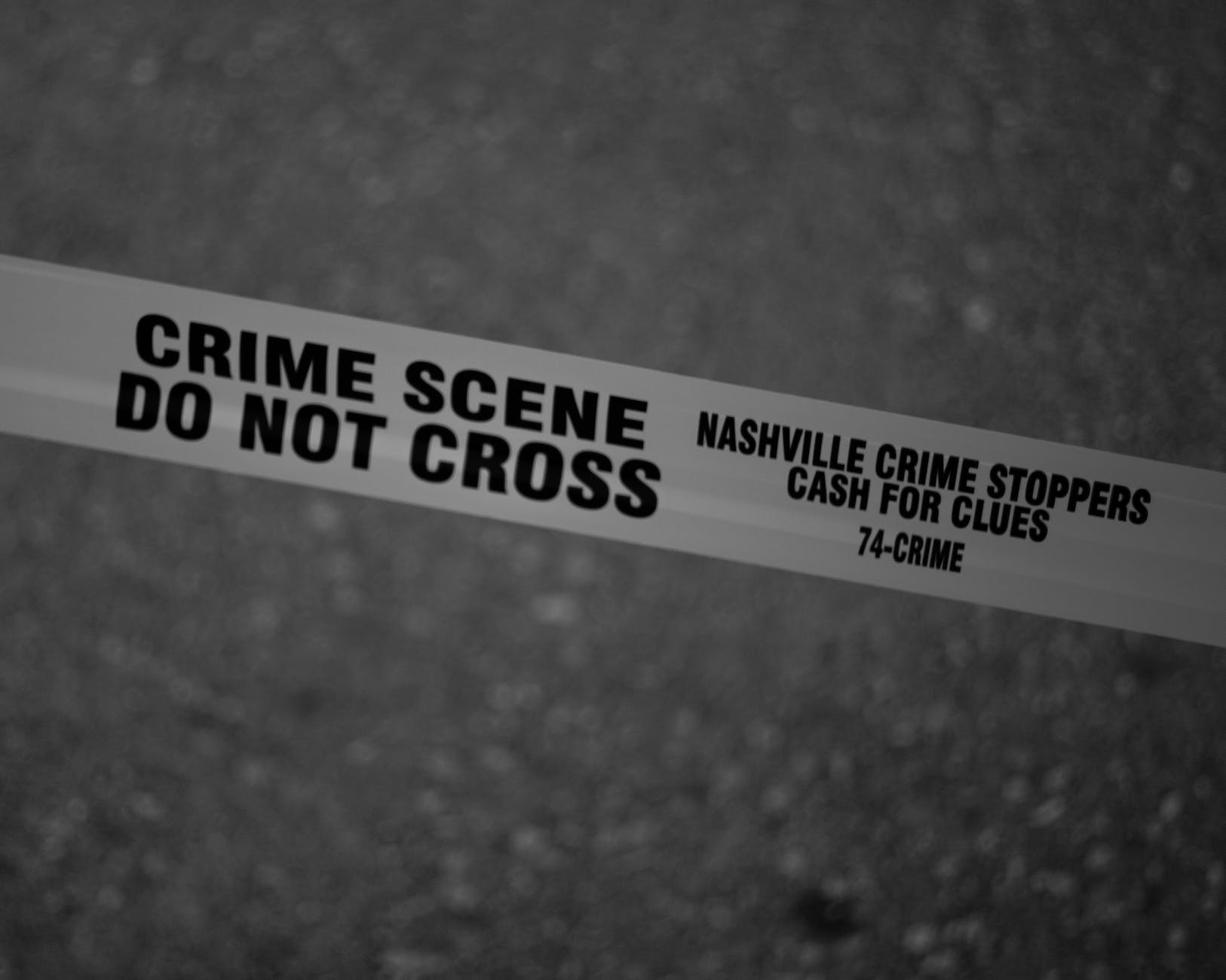 grayscale photo of crime scene do not cross tape